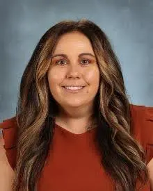 A woman with long hair and red shirt smiling.