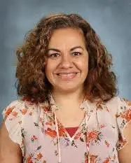 A woman with curly hair and floral shirt.