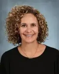 A woman with curly hair and a black shirt