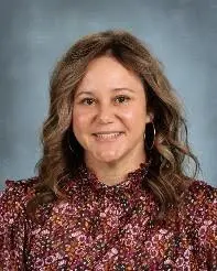 A woman with long hair wearing a floral shirt.