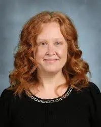 A woman with red hair and a black shirt.