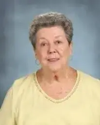 A woman in yellow shirt and silver earrings.