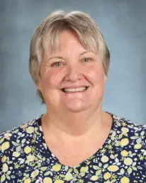 A woman with short hair and a floral shirt.