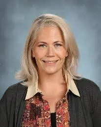 A woman with blonde hair and a floral shirt.