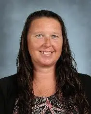 A woman with long hair is smiling for the camera.