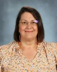 A woman with glasses and a floral shirt.