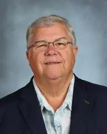 A man with glasses and a suit jacket.