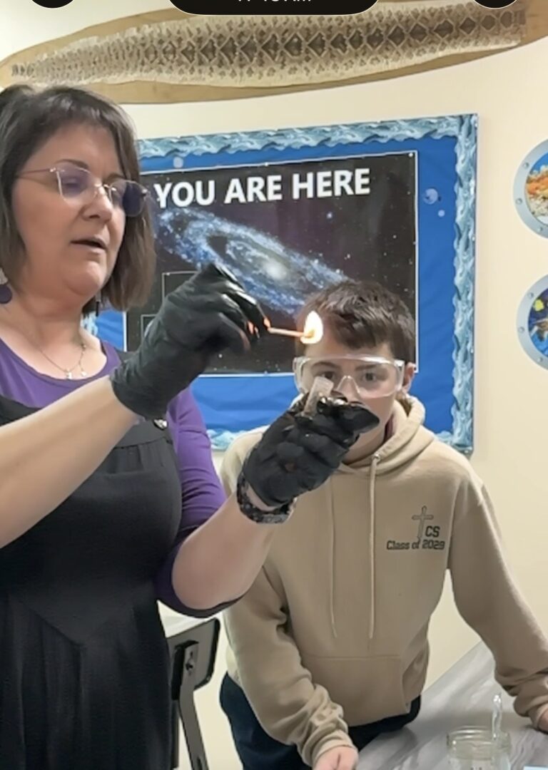 Teacher and student science experiment with flame