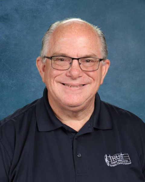 Smiling older man in navy polo with logo